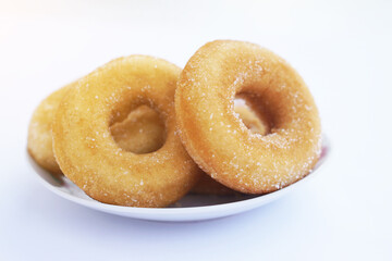 Homemade sugar milk donuts on white plate, soft and fluffy texture, buttery aroma, non-greasy fried snack. Delicious treat for eating or selling, concept of fried pastry and sweet dessert.  