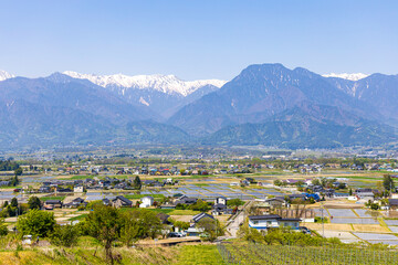 安曇野の町の風景と北アルプスの残雪の山並み