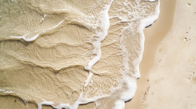 Natural flow patterns in beige sand, shaped by retreating seawater, photographed from above