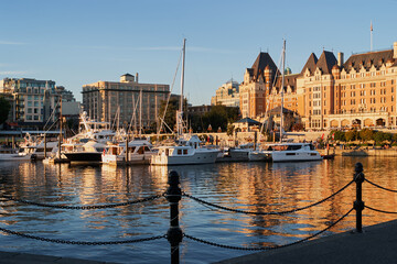 Fototapeta premium Boats docked in front of the historic Fairmont Empress Hotel at sunset in Victoria, Vancouver Island, Canada.