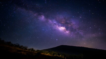 Fototapeta premium Milky way galaxy over a dark mountain range.