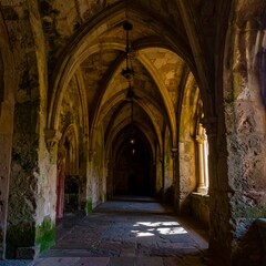 Fototapeta premium Sunlit stone hallway in ancient building, arched ceilings, aged walls, and a sense of history
