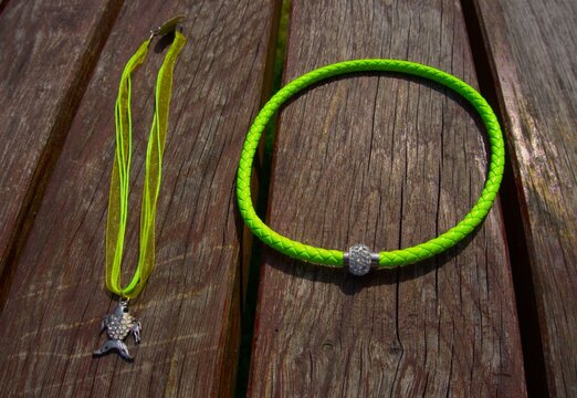 Vibrant green jewelries on a wooden table outdoors 