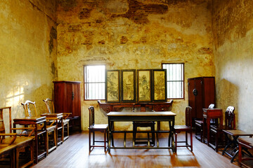 Vintage and rustic grunge concrete wall and wooden floor in literature room with old furniture of Chinese style