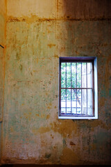 Old wrought iron window with vintage and rustic grunge concrete wall interior of vintage house