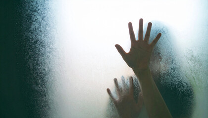 Silhouette of a Person Behind Frosted Glass with Hands Pressed Against It, Evoking Fear and Isolation