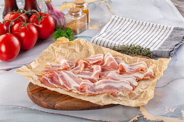 Sliced pork bacon over board