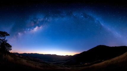 Milky way arc over a valley at night.