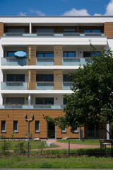 Facade of a modern apartment building with a green courtyard