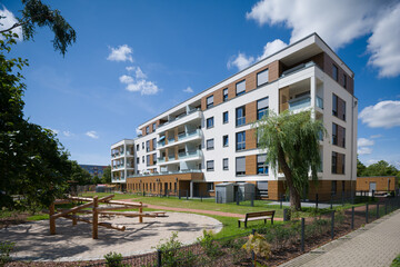 Modern apartment building with a playground in a green courtyard