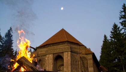 Campfire near ancient building at dusk
