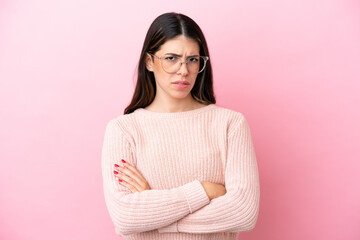 Fototapeta premium Young Italian woman isolated on pink background With glasses and arms crossed