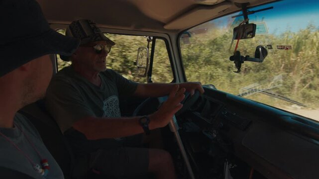 Two hippies travel by the old classic bus in Brazil. Elderly and young men travel by the retro classic car and talk