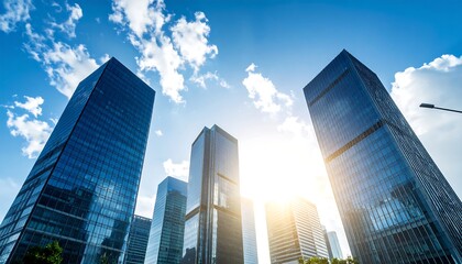 Fototapeta premium Low-angle view of modern skyscrapers under a bright, sunny sky