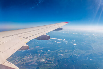 Obraz premium View from the airplane window at a beautiful cloudy sky and the airplane wing
