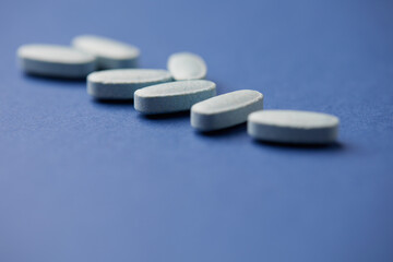 Multivitamin tablets on bright paper background. Close up. Copy space	