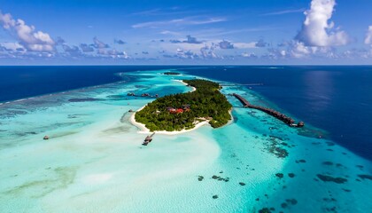 Aerial view of a tropical island resort with turquoise waters and overwater bungalows in the Maldives