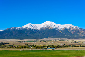 A view of the Mount Princeton range, its snowcapped peaks standing out against a clear blue sky in autumn.