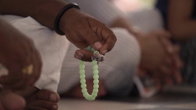 Closeup shot of hand with chanting beads. Spirituality and faith.