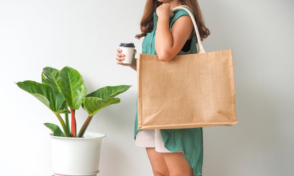 Woman holding  jute bag or sack bag on white background. Reusable shopping bag. Natural material. Zero waste. Plastic free. Eco friendly concept.