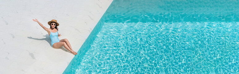 Happy woman in swimsuit relaxing at the pool in luxury hotel. Summer, vacation concept. Copy space