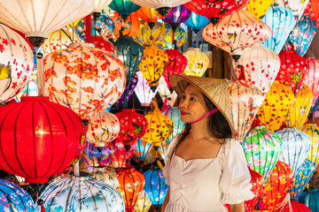 Asian traveler woman is enjoy looking lanterns in old town Hoi An, Female choosing a lamp at Hoi An ancient town, Vietnam