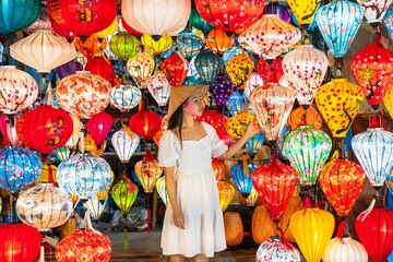Asian traveler woman is enjoy looking lanterns in old town Hoi An, Female choosing a lamp at Hoi An ancient town, Vietnam
