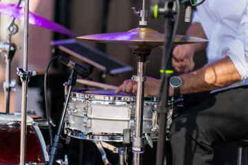Drummer performing live on snare drum with sticks, focus on rhythm and sound, concert stage detail, creative energy, music performance, live art, beat, tempo, harmony and musical creativity