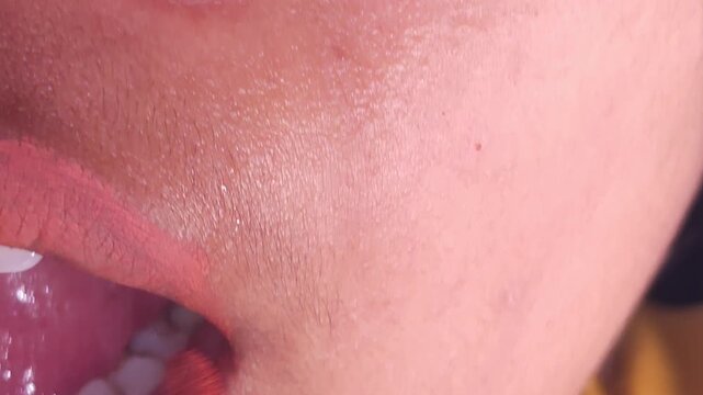 Macro lips. Professional makeup. Closeup of Indian teenage girl mouth with lipstick on lips. Beauty and makeup. Close up cosmetics for lips. Make up, applying lipstick, lips gloss on mouth. Beauty lip