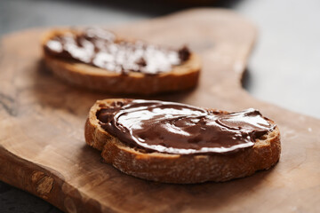 Ciabatta slices with chocolate spread on olive wood board
