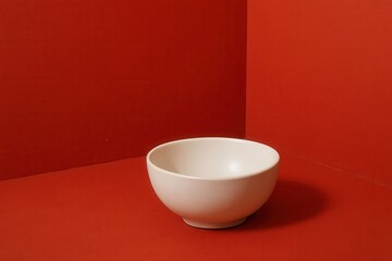 A White Bowl Against a Red Backdrop