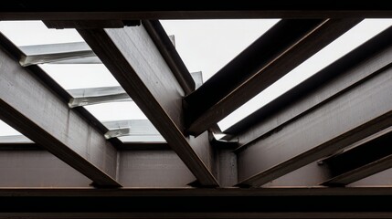 Fototapeta premium Industrial metal beams forming an abstract geometric composition in a construction setting with cool steel tones. 