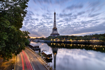 Obraz premium Scenic view of the Tour Eiffel Tower reflecting in the Seine River, captured from a bridge in Paris at Dusk.