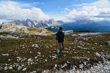 Obraz premium A trekker enjoying the beautiful view of Bolzano in the Catinaccio in the Dolomites, Italy