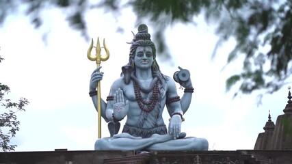 lord shiva statue outdoors, hindu god shiva sculpture, religious shiva idol with trident, divine shiva murti in temple stock video. - Powered by Adobe