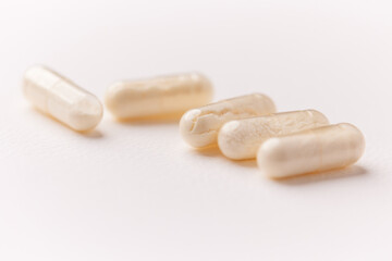 Coenzyme Q10 capsules. Antioxidants. Concept for a healthy dietary supplementation. Bright paper background. Soft focus. Close up. Copy space.	