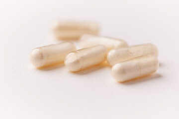 Coenzyme Q10 capsules. Antioxidants. Concept for a healthy dietary supplementation. Bright paper background. Soft focus. Close up. Copy space.	