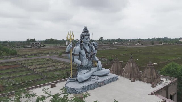 lord shiva statue drone view, hindu god shiva murti aerial shot, trishul holding shiva idol, religious temple shiva sculpture stock video.