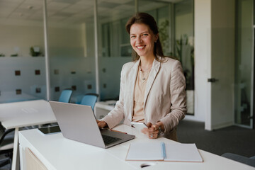 A Professional Woman Engaged in Work within a Modern Office Environment Using Her Laptop