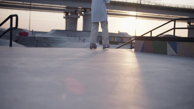 Athlete in inline skates rides slowly along plain stone ground