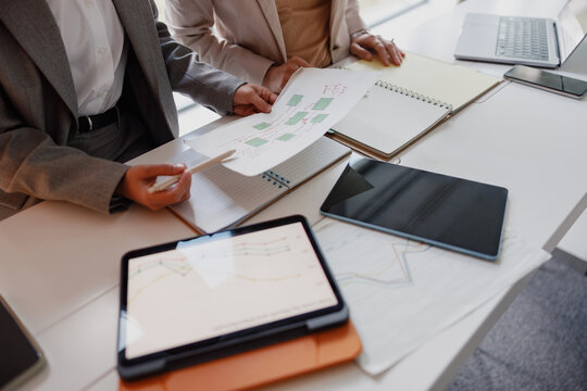 A Business Meeting Utilizing Digital Devices, Papers, and Various Documents for Efficiency
