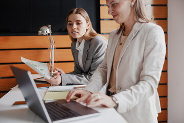 Businesswomen are effectively collaborating in a modern office, showcasing teamwork and creativity