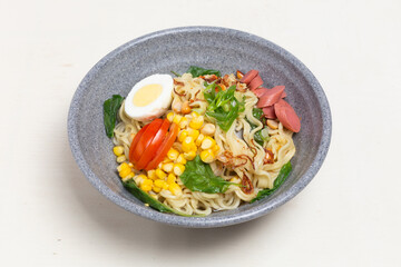 A warm bowl of Indomie Kuah, a popular Indonesian instant noodle soup. This image highlights the rich chicken broth, savory noodles, and fresh vegetables.