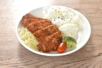 deep fried slice pork or tonkatsu with cabbage tomato and broccoli vegetable on black sesame rice in plate