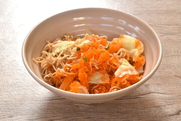 fried instant yellow noodles and cabbage with carrot topping shrimp egg on bowl