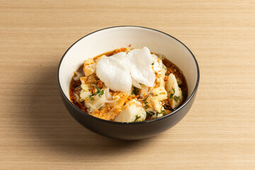 Tahu Kupat is a savory and flavorful Indonesian street food. This photo shows the crispy tofu, soft rice cakes, and fresh bean sprouts.