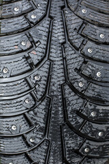 winter studded tire for snow and ice. directional tread pattern. close-up on a black background, close-up.