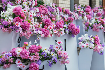 Vibrant floral arrangement in white planters, featuring pink, purple, and white blossoms, creating a colorful and elegant urban garden display