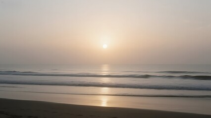 Fototapeta premium Sunset over a calm beach with gentle waves and a clear horizon