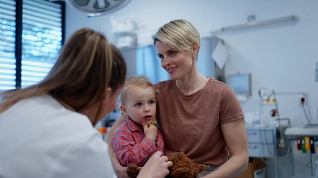 Pediatrician examing little boy during preventive health check up.